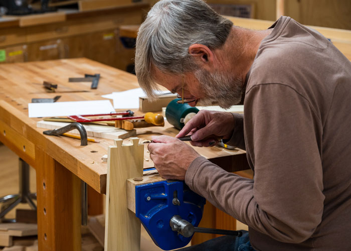 Woodworker carving dovetail